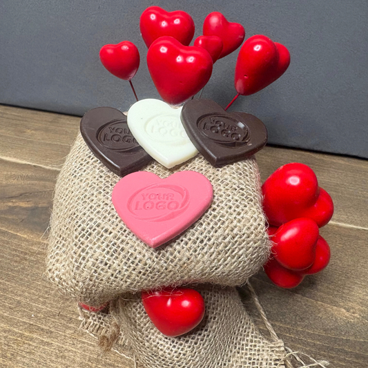Heart-shaped chocolates with a custom logo in dark, white and pink chocolate