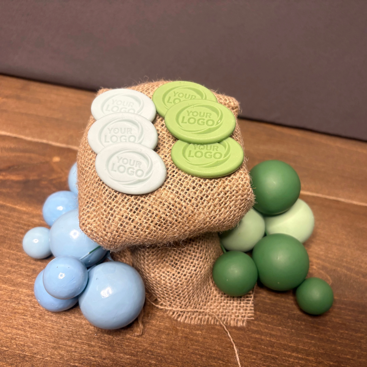 Custom oval silicone products with embossed logo displayed on burlap fabric
