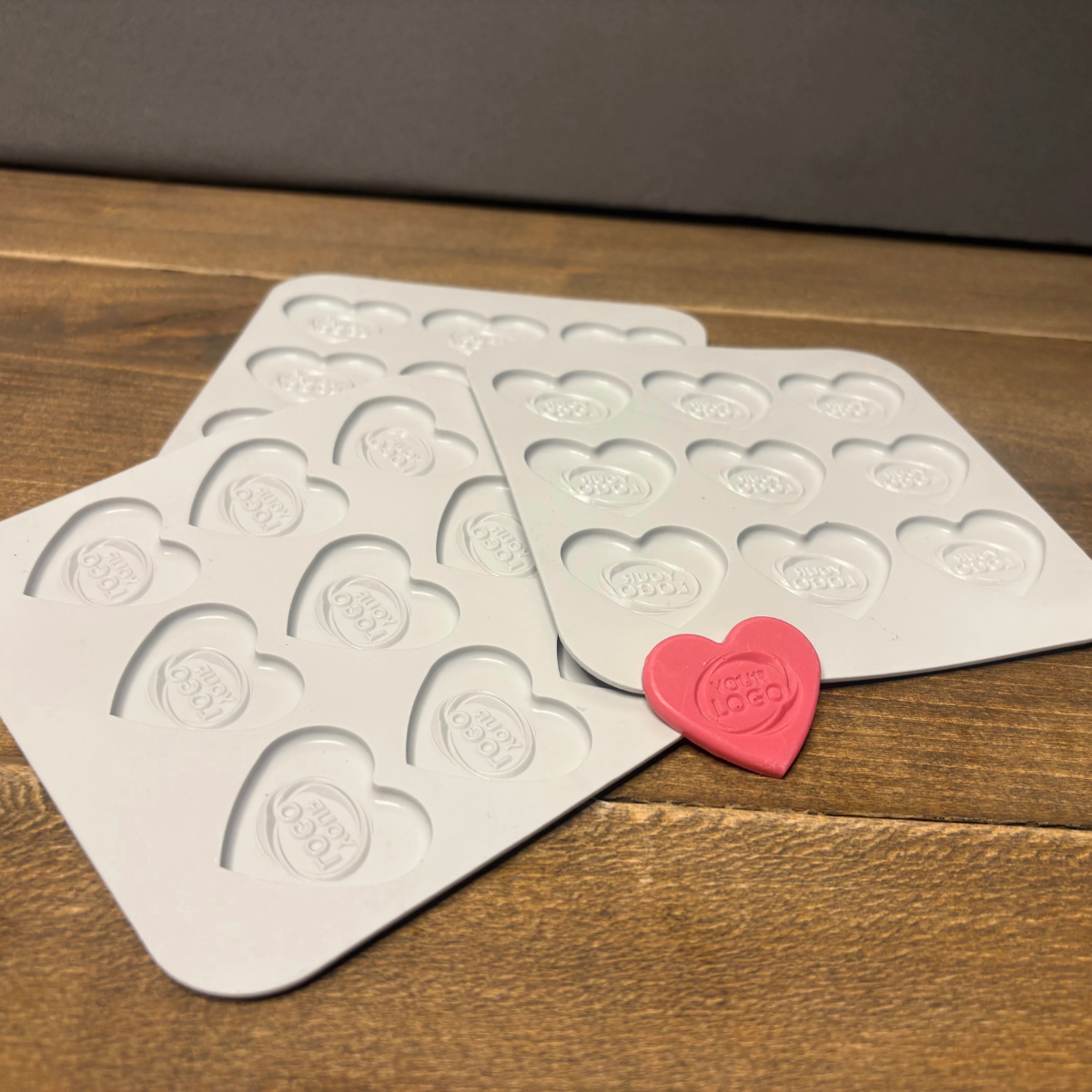 Flat lay of custom heart chocolates in different colors with coffee beans