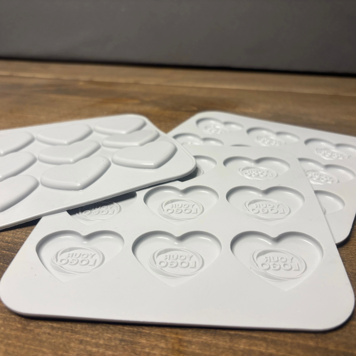Side view of custom heart silicone molds with engraved logo cavities